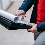 Close-up of a professional person reviewing documents outdoors. Engaged in work with focus on writing materials. — A Brief Gu
