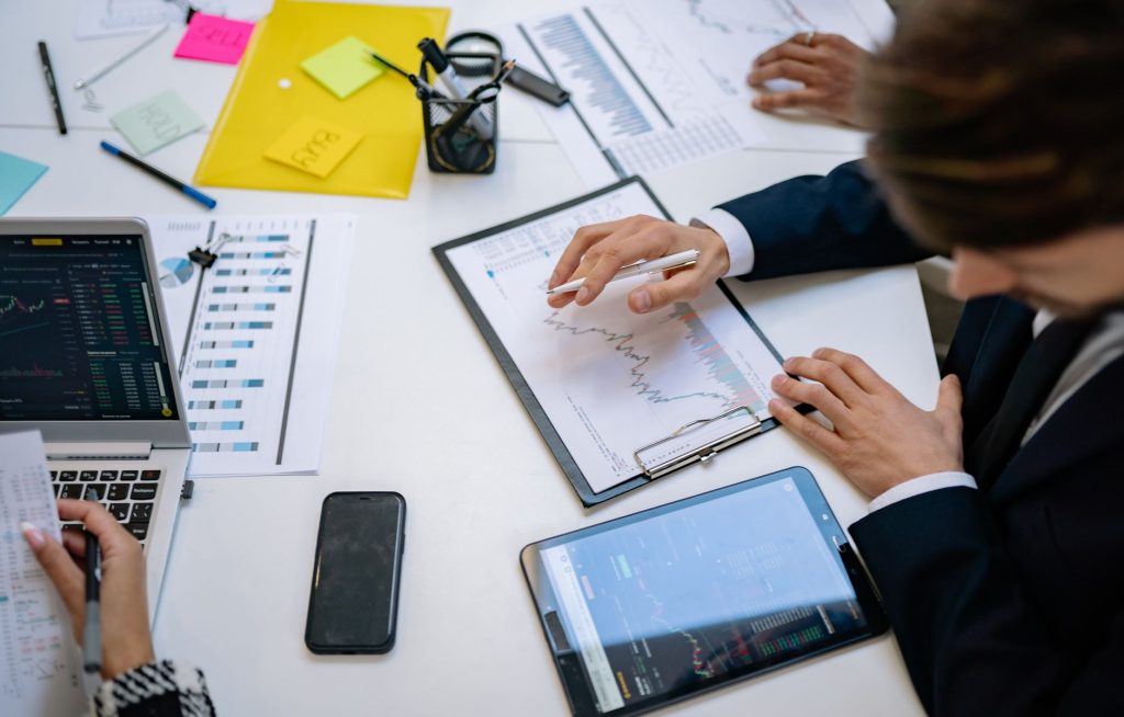 Team reviewing financial charts and digital data on tablets in an office setting. — Professional Asbestos Test for Building S