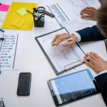Team reviewing financial charts and digital data on tablets in an office setting. — Professional Asbestos Test for Building S